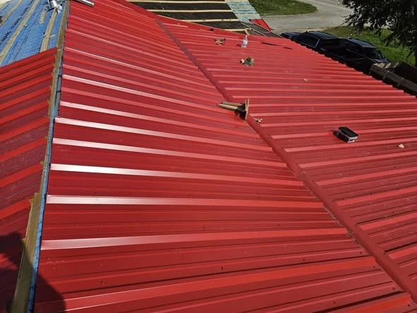 Red metal roofing installed by DeMilan